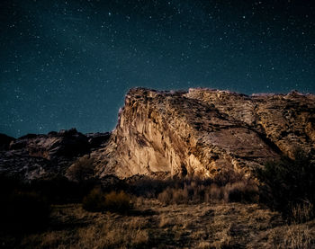 Low angle view of rock formation against sky at night