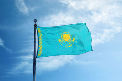 Low angle view of flag against blue sky