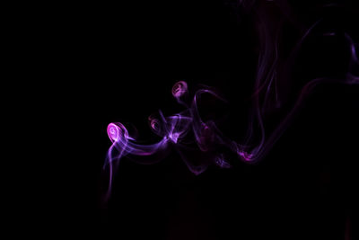 Purple smoke against black background