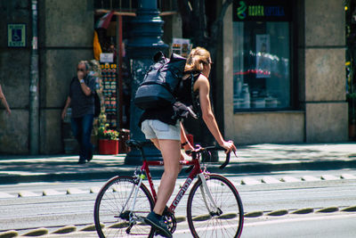 Full length of woman with bicycle on street