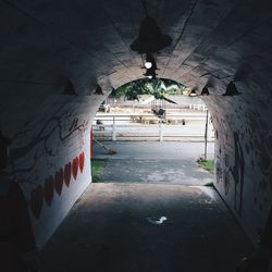 Empty road amidst buildings in tunnel