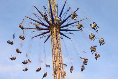 Low angle view of chain swing ride against clear blue sky