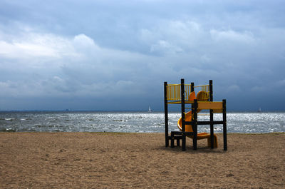 Lifeguard hut on beach against sky