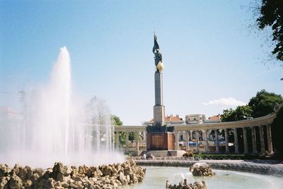 View of fountain against buildings in city