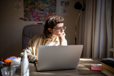 Young woman using laptop at home