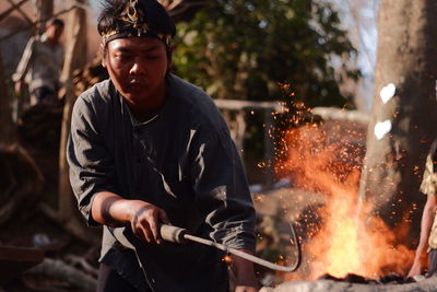 Midsection of man holding burning fire