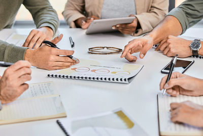 Midsection of business colleagues working on table