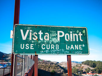 Road sign against clear blue sky