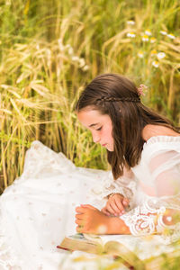 Portrait of young woman sitting on field