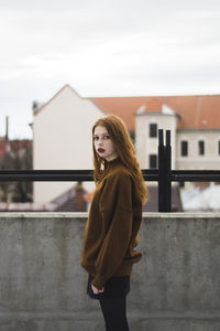 Portrait of beautiful woman standing against sky