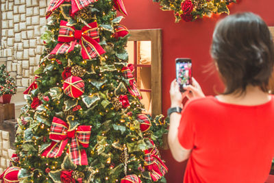 Rear view of woman with christmas tree