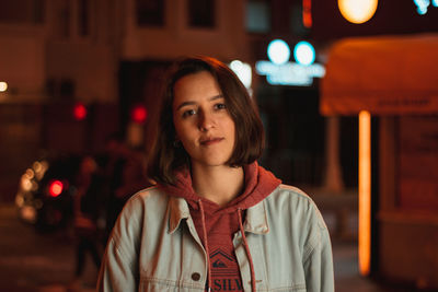 Portrait of young woman standing outdoors at night