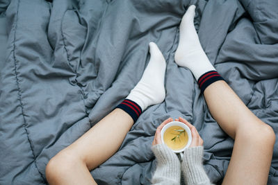 Low section of man sitting on bed