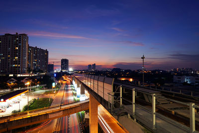 High angle view of light trails on street amidst buildings at night