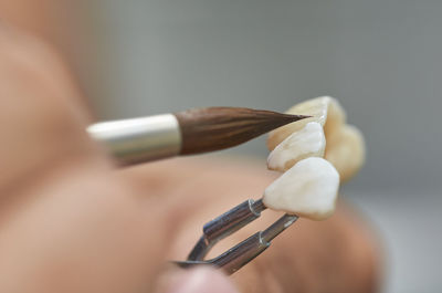 Close-up of hand painting artificial teeth
