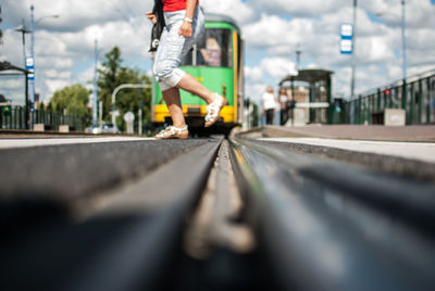 Low section of person crossing railroad track in city