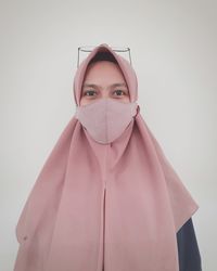 Portrait of a young woman against white background