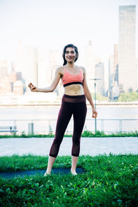 Full length of smiling young woman in city