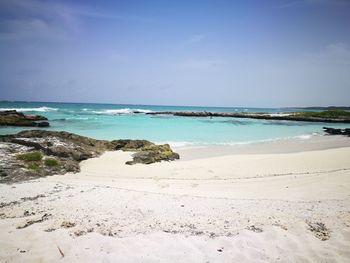 Scenic view of beach against blue sky