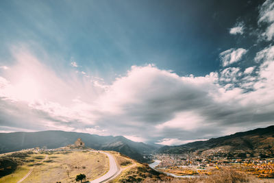 Aerial view of city against cloudy sky