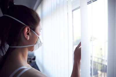 Portrait of woman looking through window
