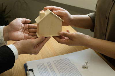 High angle view of people holding book on table