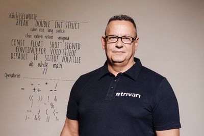 Portrait of confident muscular man standing against whiteboard