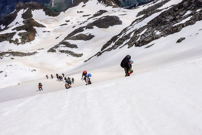 People walking on snow covered mountain
