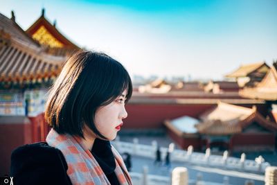 Portrait of woman looking at camera against sky