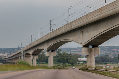 Bridge over highway against sky in city