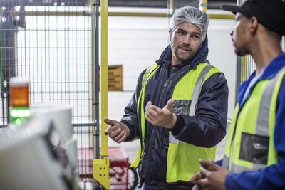 Two workers discussing in factory