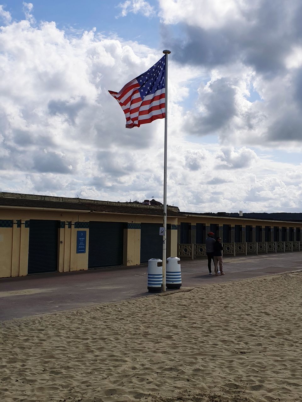 FLAGS ON BEACH AGAINST SKY