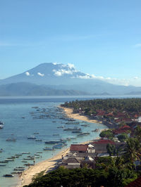 Scenic view of sea and buildings against blue sky