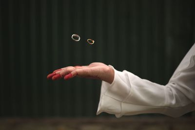 Cropped hand of woman tossing rings outdoors