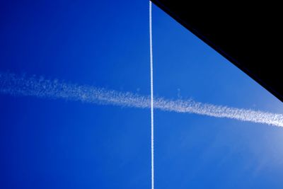 Low angle view of vapor trail against clear blue sky