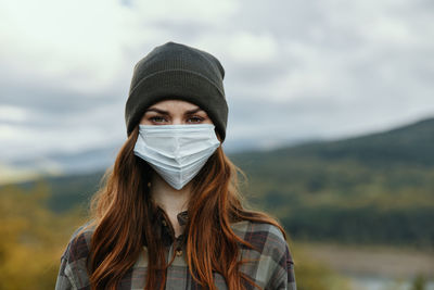 Portrait of young woman against sky