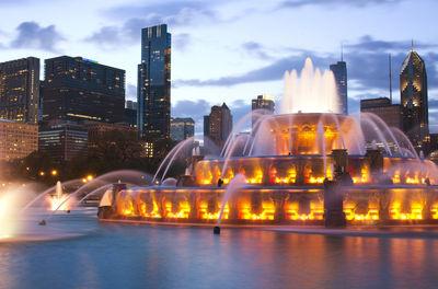 Illuminated buckingham fountain by cityscape