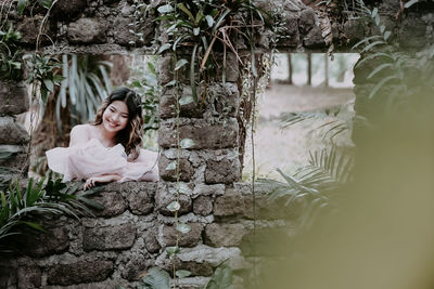 Portrait of young woman sitting on rock