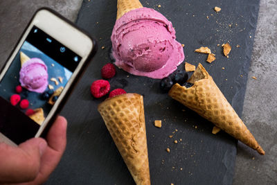 High angle view of hand holding ice cream on table