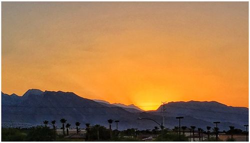 Scenic view of silhouette mountains against sky at sunset