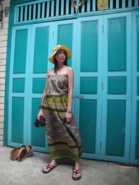 Young woman standing against closed door