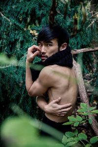Young man with arms raised on plant