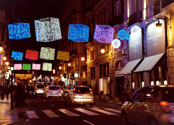 Illuminated cars on road in city at night