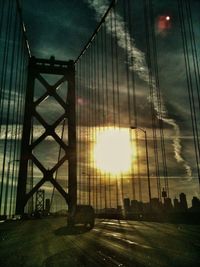 Low angle view of sun shining through clouds