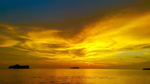 Scenic view of sea against dramatic sky during sunset