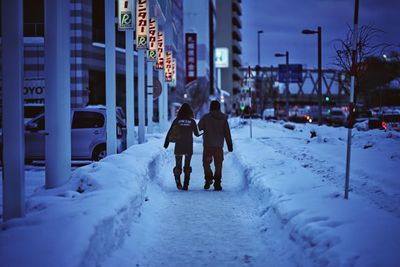 People on snow covered city in winter