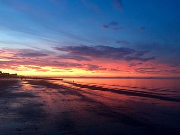 Scenic view of beach against romantic sky at sunset