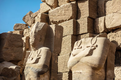 Statues of ancient egyptian pharaohs and gods. various hieroglyphs on the walls.