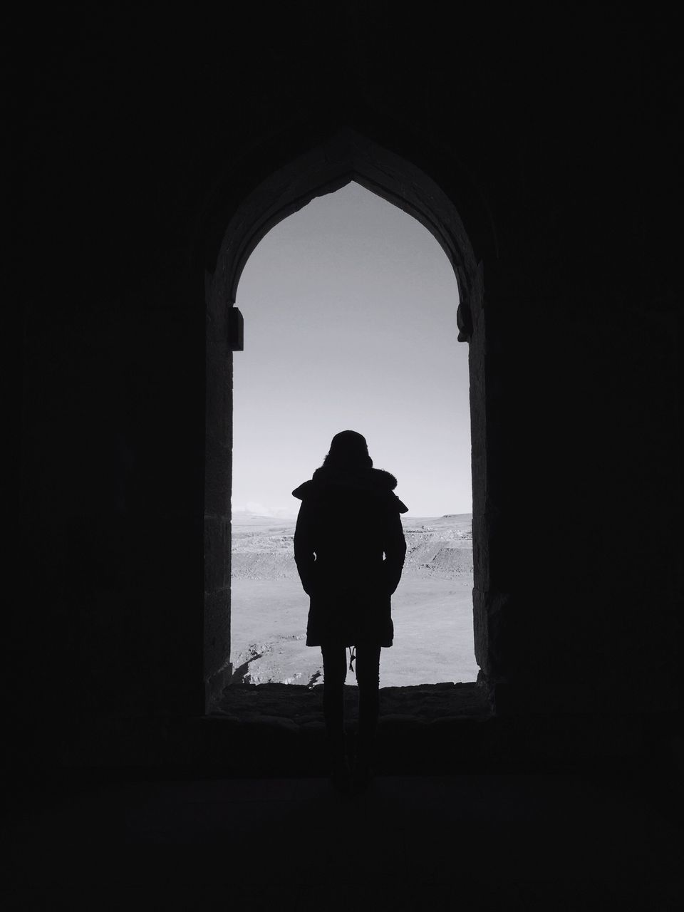 indoors, arch, full length, silhouette, standing, rear view, lifestyles, window, copy space, architecture, built structure, men, archway, leisure activity, person, dark, walking, clear sky