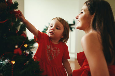 Side view of mother and daughter at home